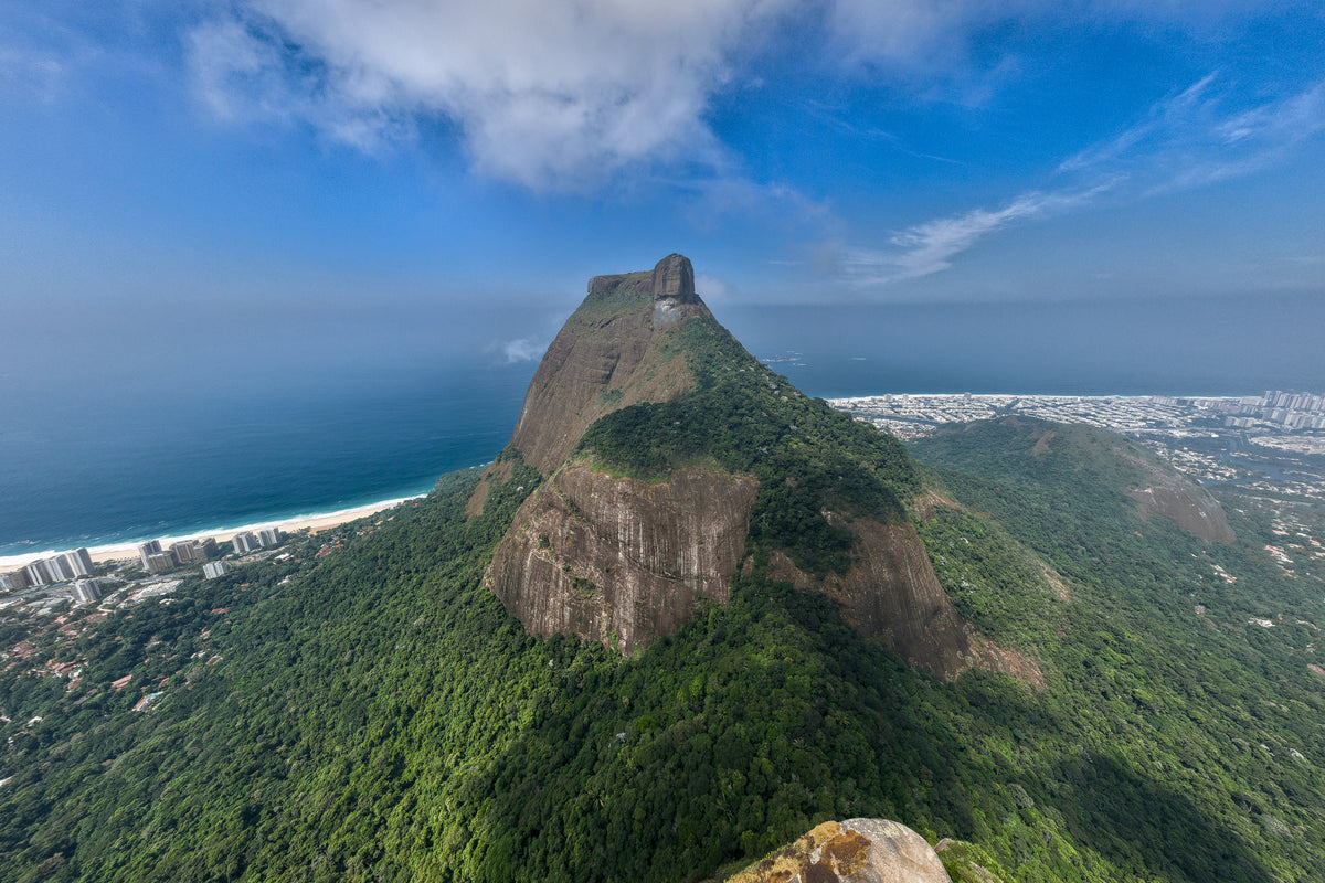 Aerial view of the rugged Pedra da Gávea mountain peak rising above the Atlantic coastline in Brazil.
