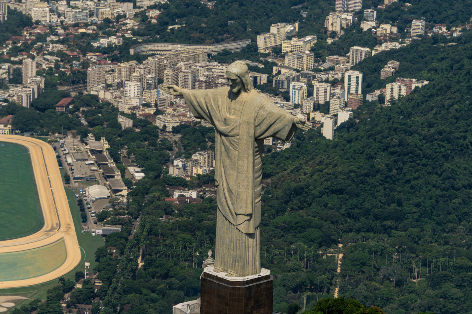Aerial view of the Christ the Redeemer statue overlooking the city of Rio de Janeiro and the Jockey Club racetrack.