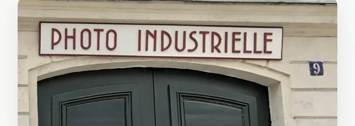 The Photo Industrielle sign still hanging above the door at 9 Rue Cadet, Paris.